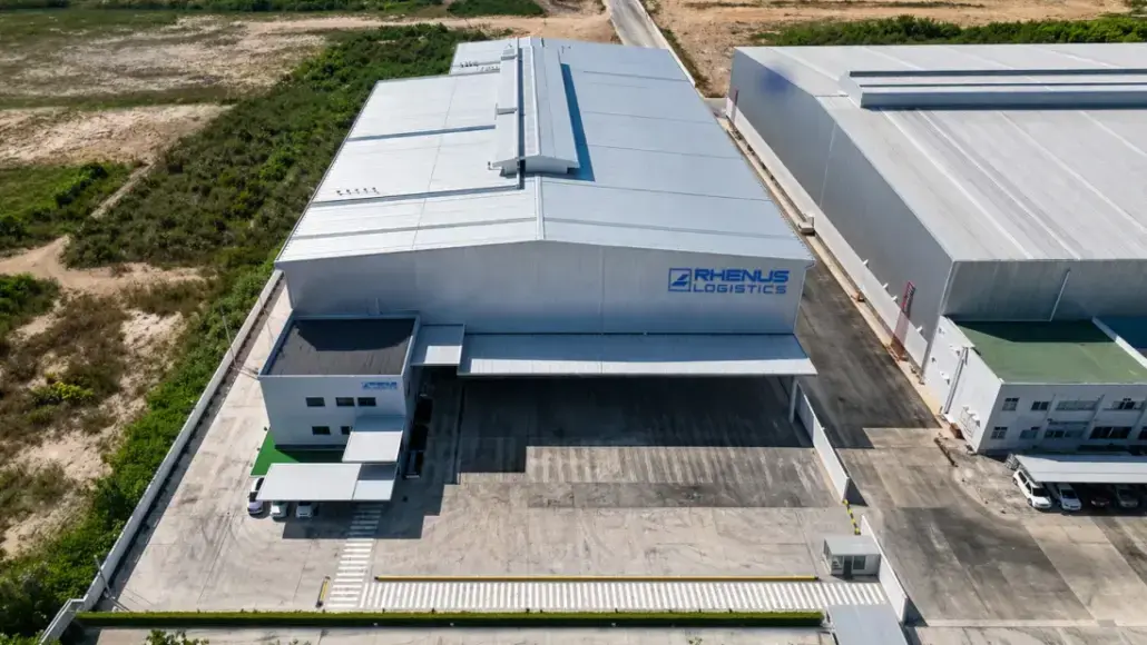 Aerial view of a RHENUS Logistics warehouse with loading docks and a paved yard area.”